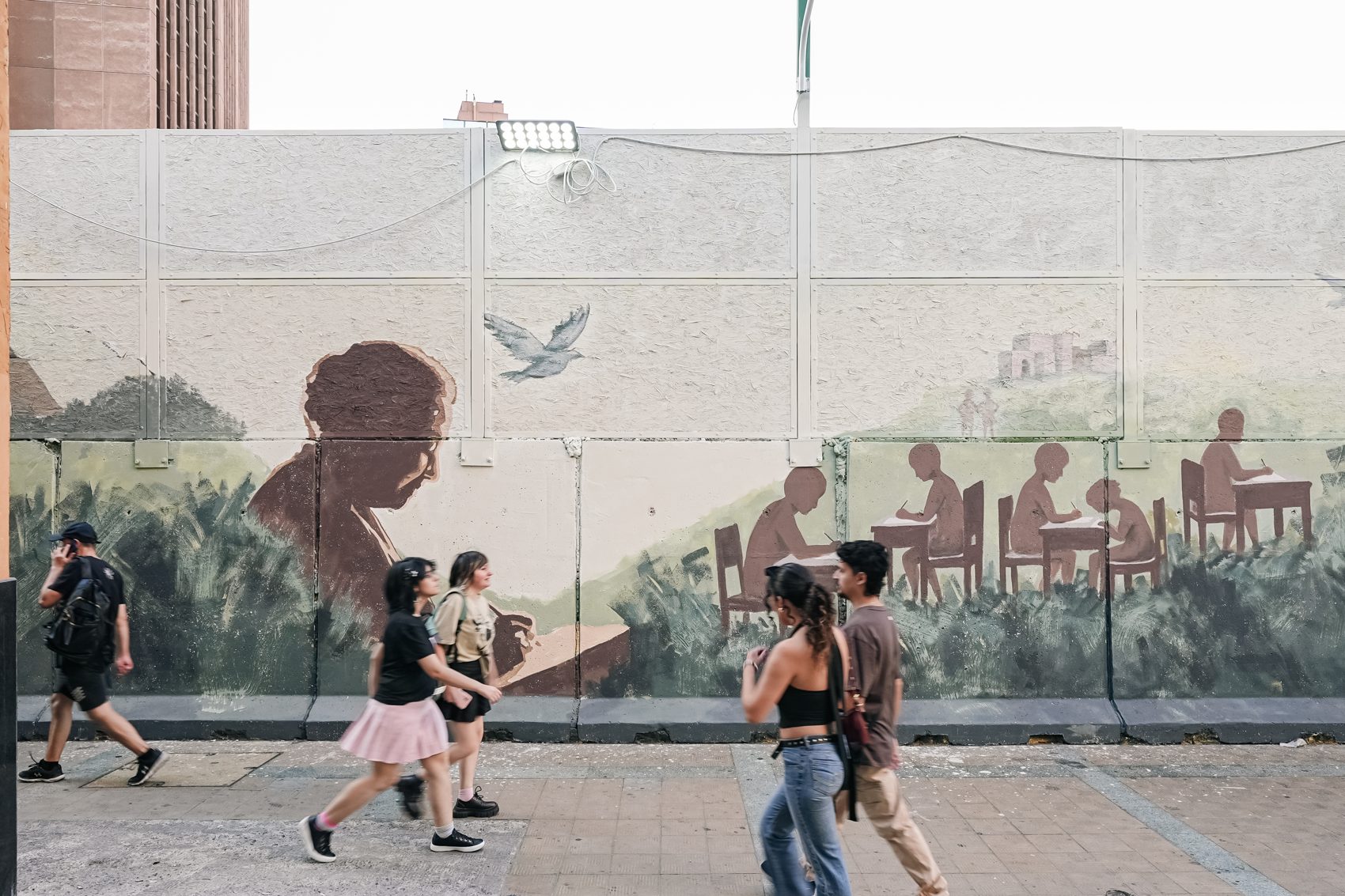 Personas frente al mural del Metro